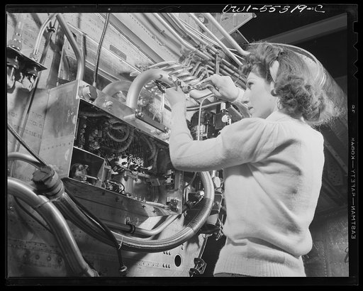 Engine controls are assembled on the firewall of a North American B-25 bomber by this final assembly worker