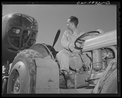 A Negro employee on North American's flight ramp tows a B-25 bomber into place