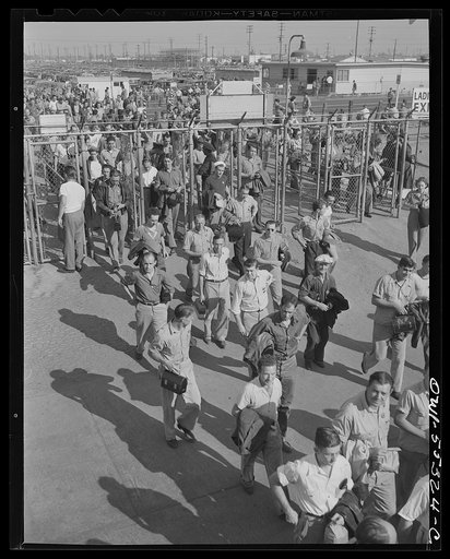 North American employees display their badges and identification cards as they enter the main gate
