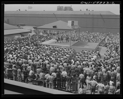 A vairety of programs are presented to North American employees during their lunch period. Here thousands watch a boxing match between two employees