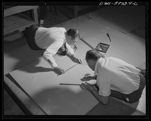 Two loftsmen scribe a template on metal that will later be cut and form the master template to form thousands of parts for North American bombers and fighters