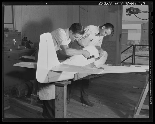 A scale wind tunnel model of North American Aviation's P-51 fighter is prepared by two model shop employees before another test is made to determine its flight characteristics. All measurements on these models are within two thousandths of an inch