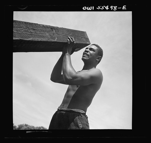 Negro laborers carrying and laying railroad ties for a spur line into a coal storage space for the federal government