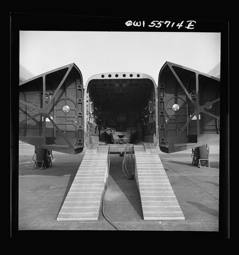 Rear view of C-82 shown at demonstration of equipment held by United States Army Air Forces. The after end of the fuselage opens to the complete height and width of the interior, which is square. In order to allow freight to be stowed directly from a truck, the bottom of the fuselage is the height  