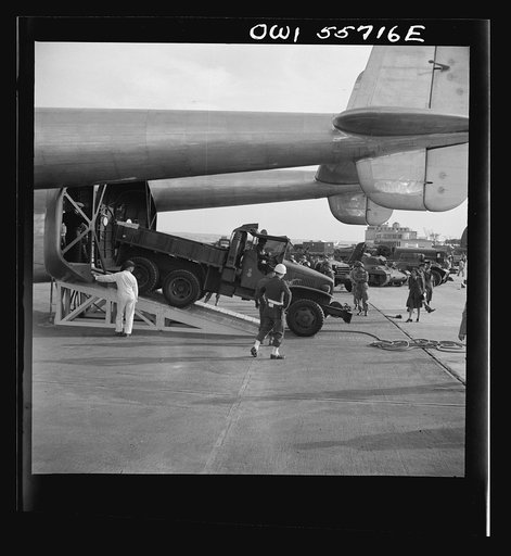 Heavy Army truck being driven off Army Air Forces' new C-82 in demonstration of equipment held by United States Army Air Forces. Note twin boom tail