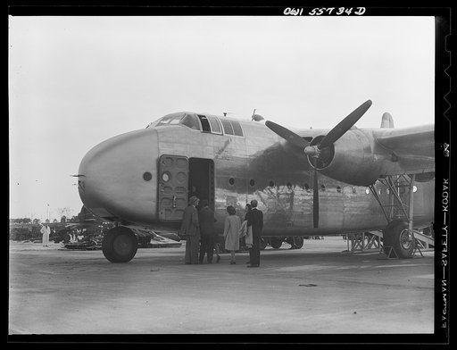 Front side view of C-82, the newest transport shown at demonstration of equipment held by United States Army Air Forces. It has twin boom tail, wing span of 106 feet, and tricycle landing gear. Engines are mounted at forward ends of the booms. Wings are of gull design. Developed solely for hauling h