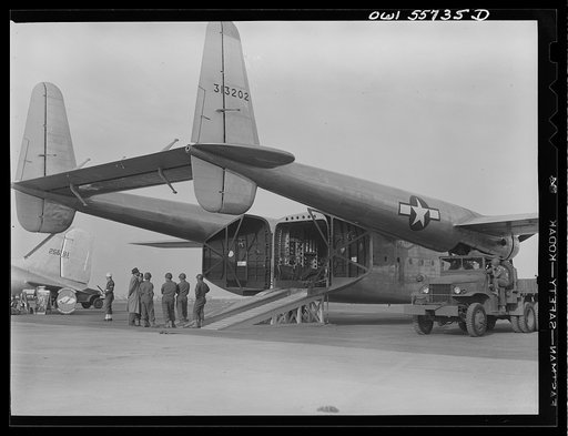 Rear view of new C-82 showing twin boom tail and square interior. This is the first war plane designed solely for hauling military cargo. It is in the 50,000 pound class and in its weight and bulk carrying capacity, will enable the air transport of ninety percent of the heavy equipment of a standard
