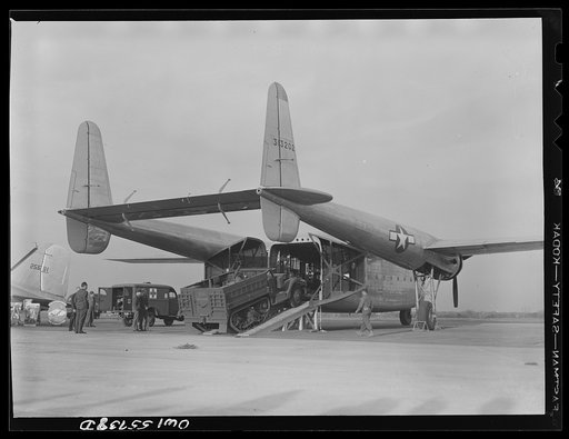 Truck being loaded into the new C-82 at demonstration of equipment held by United States Army Air Forces. The after end of the fuselage opens to the complete height and width of the interior, which is square. This is first plane designed solely for hauling military cargo, and is the product of the c