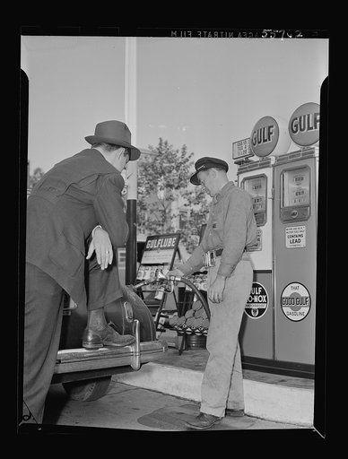 Gas station attendant at service station filling tank of a motorist's Dodge car. Washington, D.C.