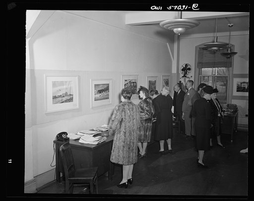 Installation of the United States Office of War Information (OWI) exhibit of original drawings and paintings by artists now in the armed forces. Preview, before shipping to Australia, held at the office of the Overseas Picture Division in the Auditor's Building