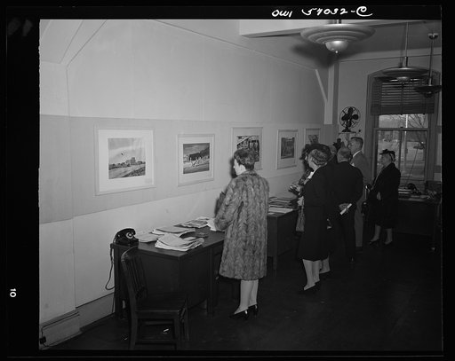 Installation of the United States Office of War Information (OWI) exhibit of original drawings and paintings by artists now in the armed forces. Preview, before shipping to Australia, held at the office of the Overseas Picture Division in the Auditor's Building