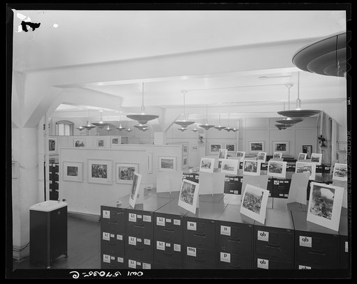 Installation of the United States Office of War Information (OWI) exhibit of original drawings and paintings by artists now in the armed forces. Preview, before shipping to Australia, held at the office of the Overseas Picture Division in the Auditor's Building