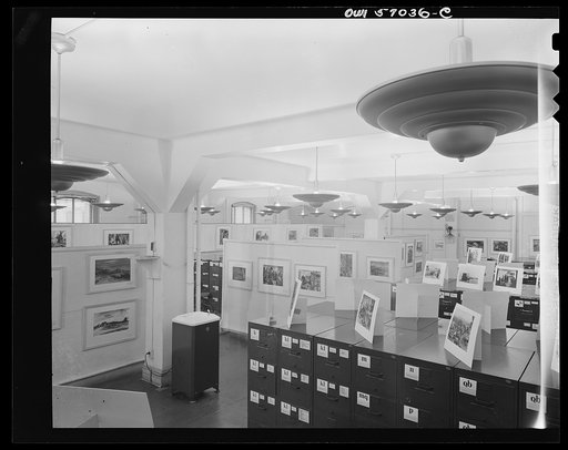 Installation of the United States Office of War Information (OWI) exhibit of original drawings and paintings by artists now in the armed forces. Preview, before shipping to Australia, held at the office of the Overseas Picture Division in the Auditor's Building