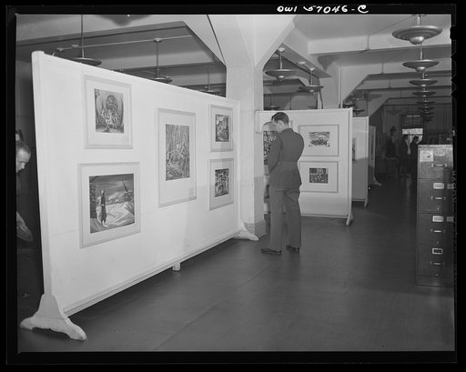 Installation of the United States Office of War Information (OWI) exhibit of original drawings and paintings by artists now in the armed forces. Preview, before shipping to Australia, held at the office of the Overseas Picture Division in the Auditor's Building