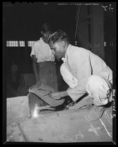 United States "lend-lease" program in eastern India. An Indian workman, using an American welder which was supplied under lend-lease, welds an armor plate on a nearly completed combat car