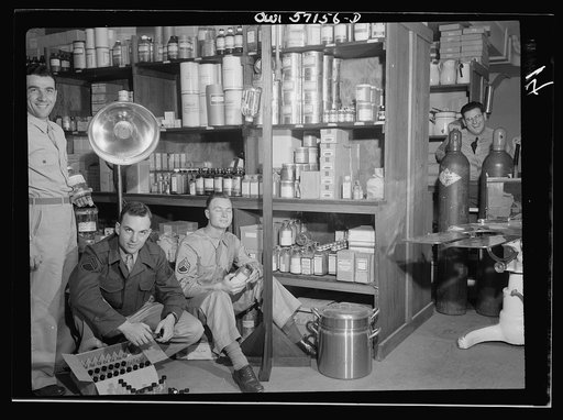 Melbourne, Australia. United States Army hospital. Left to right - Sargeant Alfred Baron, Newark, New Jersey; Staff Sargeant J. N. Sproule, Troy, New York; Staff Sargeant James R. Barbee, Springhope, North Carolina; Private Paul Greene, New York City, in medical store room
