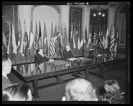 Representatives of Turkey and Egypt sign the Declaration by United Nations. Mahmond Hassen, Minister of Egypt, speaks for his county before signing the declaration. Seated left to right, Orhan H. Eral "Charge d'Affaires ad interim of Turkey,"  Joseph C. Grew, Undersecretary of State and