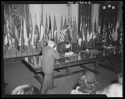 Representatives of Turkey and Egypt sign the Declaration by United Nations. Joseph C. Grew looks on as Orhan H. Eral, "Charge d'Affaires ad interim of Turkey" signs the declaration
