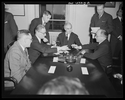 French conclude agreement on lend-lease and reverse lend-lease. Jean Monnet, representative of the French Provisional Government signs agreements. Left to right: Judson Hannegan, F.E.A., Henri Bonnet, French Ambassador, Joseph C. Grew, Undersecretary of State and Jean Monnet