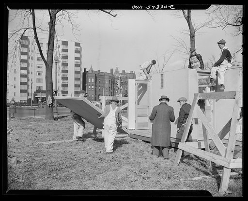 Houses for Britain. Workmen about to put a panel in place in the model house erected by the Federal Public Housing Authority at Scott Circle, Washington, D.C. This house is of the type of pre-fabricated temporary emergency house which the United States plans to ship to Great Britain under lend-lease