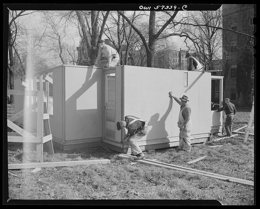 Workmen assembling model house of the type which United States will ship to Great Britain under lend-lease. Designed for a minimum use of critical materials, these  pre-fabricated temporary emergency houses will aid in alleviating the critical housing shortage in Great Britain due to bombings. Procu