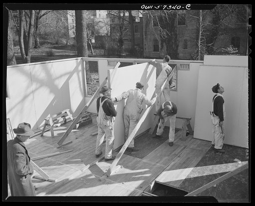 Houses for Britain. Putting a partition in place in the pre-fabricated house erected at Scott Circle, Washington, D.C. of the type of temporary emergency family dwelling 30,000 of which are to be shipped by the United States to Great Britain under lend-lease. Containing two bedrooms, bathroom, livin