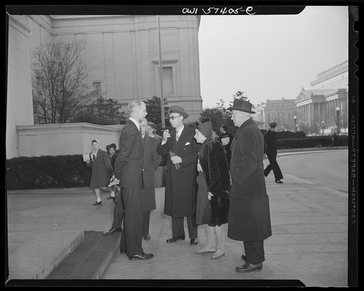 Visiting French journalists chatting outside the National Gallery of Art in Washington, D.C. with M. Rene Batigne, Curator of the French Section of the Gallery. Left to right: M. Batigne, Francois Prieur, Pierre Denoyer, Mme. Etiennette Benichon, and Louis Lombard