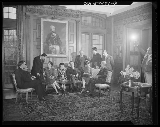 French journalists chat with Ambassador Bonnet after a luncheon at the French Embassy. Seated left to right: Pierre Denoyer, Jean-Paul Sartre, Stephane Pizella, Mme. Bonnet, Mme. Andree Viollis, Ambassador Bonnet, Mme. Etiennette Benichon, Francois Prieur. Standing: Louis Lombard, Robert Villers and