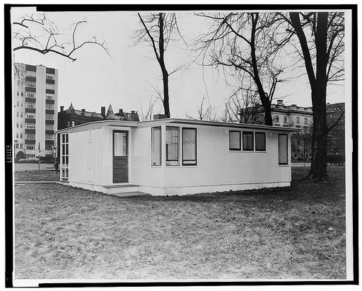 Houses for Britain. Model of prefabricated house erected at Scott Circle, Washington, D.C. of the type of temporary, emergency dwelling which it is planned to ship 30,000 to Great Britain under lend-lease. View of front of house with kitchen entrance facing camera and front entrance behind open scre