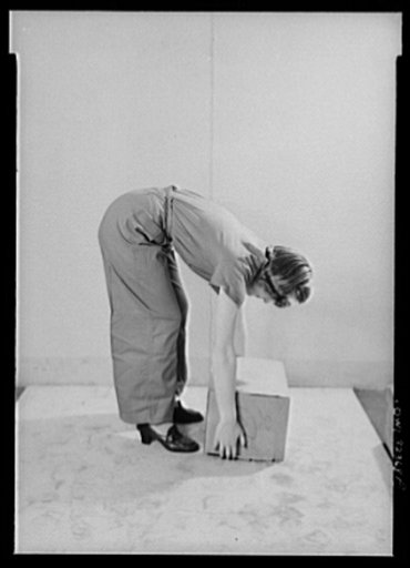Girl demonstrating the wrong way to lift a carton. U.S. Department of Labor
