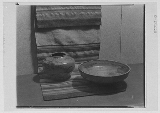 Rural arts exhibition held under the auspices of the Farm Security Administration (FSA) in the patio of the U.S. Department of Agriculture building. Jugtown pottery from the Piedmont section of North Carolina; handwoven fabric colored with vegetable dyes from the John C. Campbell Folk School, Brasst
