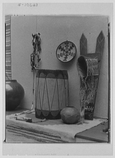 Rural arts exhibition held under the auspices of the Farm Security Administration (FSA) in the patio of the U.S. Department of Agriculture building. Handspun and woven rug from Colorado; beaded bridle and beaded papoose carrier made by Sioux Indians; small pottery and corn storage jar, drum and bask
