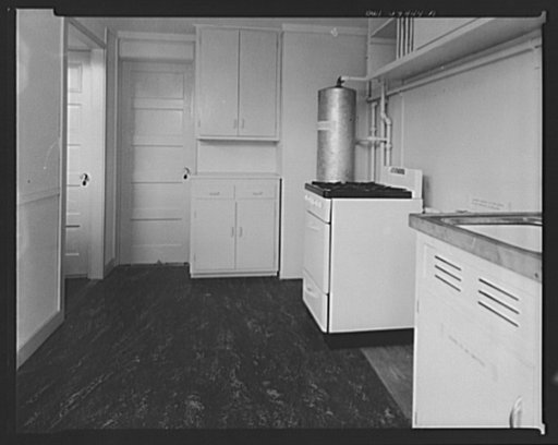 Houses for Britain. Kitchen in  prefabricated model house erected at Scott Circle, Washington, D.C. by the Federal Public Housing Authority of the type of temporary, emergency dwellings which it is planned to ship to Great Britain under lend-lease.  Door at left opens into a larder, with louvers for