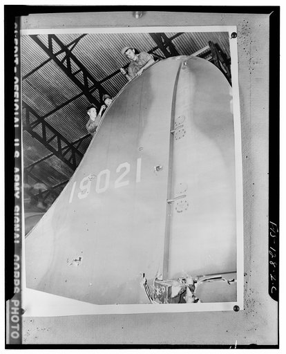 Left to right: Private Asser Llomaki of Mason, New Hampshire; Staff Sergeant D.E. Horton of Painted Post, New York; Staff Sergeant C.L. Hoopman of Ionia, Michagan working on the tail of a B-17 Flying Fortress at a replacement center somewhere in England. The bomber was damaged in raids over occupied