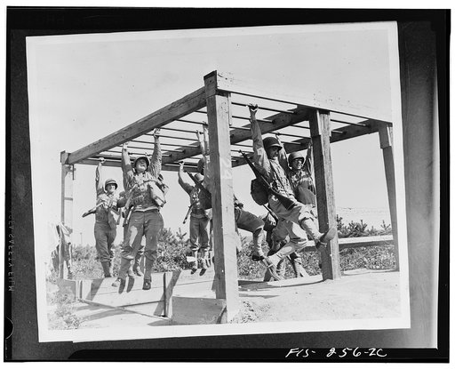 Camp Edwards, Massachusetts. Swinging across fifteen feet of horizontal ladders are soldiers of the anti-aircraft training center. This is the next-to-the-last obstacle on the course and comes at a time when a man's wind is coming hard and his arms are feeling fatigue. A fall here means a wetting to