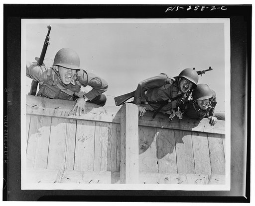 Camp Edwards, Massachusetts. Officers, as well as enlisted men, are required to train rigorously on the ani-aircraft training center's obstacle course to keep in pink of condition. Above, officers are shown completing the final obstacles of the tough course, topping the six-foot wall, the last part 