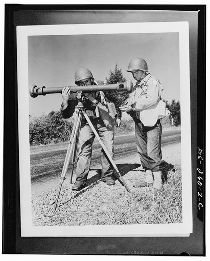 Corporal Hanry Manoni and Sergeant Joseph Loftis sight through a rangefinder in the process of aiming big guns of their artillery battery during Second Army maneuvers in Tennessee