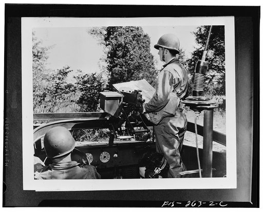 Soldiers of a reconnaissance squad on maneuvers with the Second Army in middle Tennessee cutting across the country in a scout car. Left to right: Corporal Howard Connor, driver; Private Fielder Magruder, radio operator; and Lieutenant Peter Gattino
