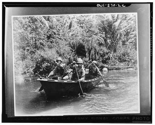 U.S. troops in the Caribbean area patrolling in an army assault belt surrounded by a tropical jungle