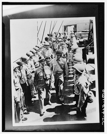Officers inspecting a transport crew carrying troops from New Caledonia to the Solomons to reinforce the Marines. Front to rear are: Vice Admiral Robert Ghormley, who was then in command of the South Pacific area; Captain Charles Paul McFeaters, commander of the transport (wearing helmet); Major Gen