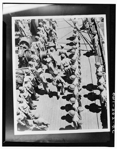 Officers inspecting the crew of the transport carrying troops from New Caledonia to the Solomons to reinforce Marines. They are: Captain Charles Paul McFeaters, commander of the transport; Vice Admiral Robert Lee Ghormley, who was then in command of the South Pacific; Major General M.F. Harmon, comm
