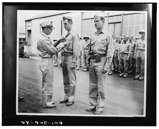 Major General M.F. Harmon, commander of the U.S. Army forces in the South Pacific, pinning the Silver Star on Major Thomas J.J. Christian. Major Thomas H. Hubbard, on the right, awaits his citation. The majors were awarded to Silver Star for gallantry in action in the Solomon Islands