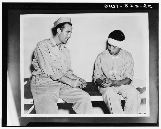 Private Henry F. Rourke shows a rosary to a wounded Jap soldier and learns that the latter is a Buddhist. Most of the captured Japs speak English, but they did little talking