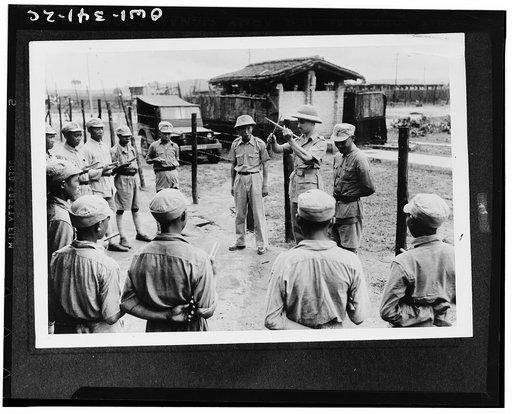 Lieutenant Carl Arnold, instructor, giving Chinese troopers their first lesson in the use of drumsticks
