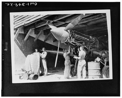 Ground crews of American Air Forces keep the engines tuned up for the Flying Tigers. Corporals J.B. Woodville, R.W. Berlansky, C.E. Lehman, and Sergeant C.E. Hoffman overhauling a P-40 after a flight