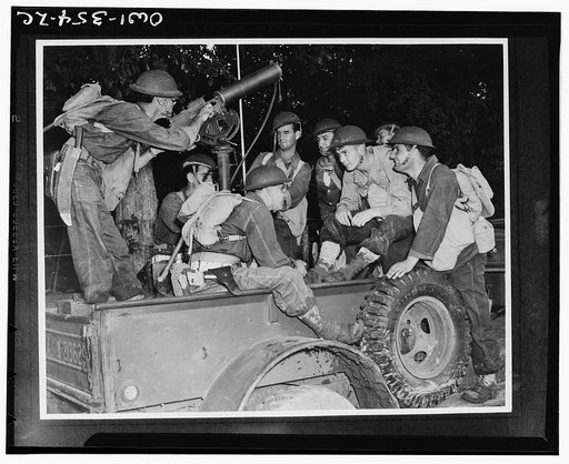 American troops in the British West Indies engaged in field maneuvers. Mobile machine gun unit getting practice under simulated war conditions. The bolo knife strapped to the belt of the soldier aiming the machine gun comes in handy for cutting through thick undergrowth and barbed wire entanglements