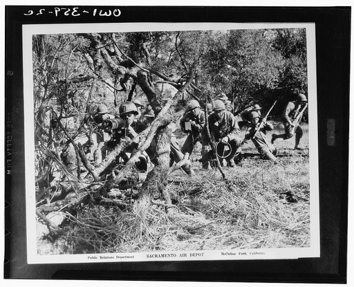 McClellan Field, California. American troops on maneuvers. Machine gun crew protecting advancing foot soldiers on the right