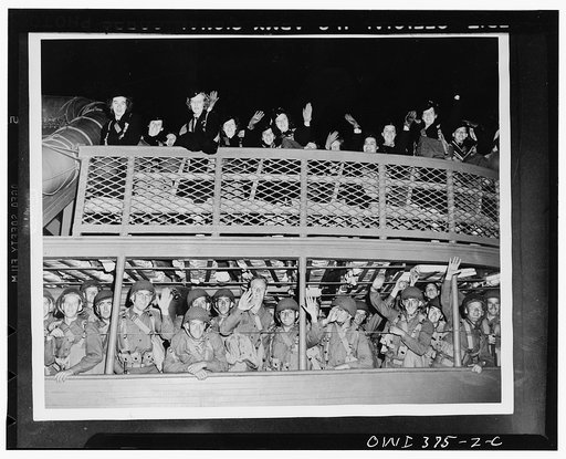 U.S. Army nurses and soldiers waving farewell as a troop ship leaves the pier