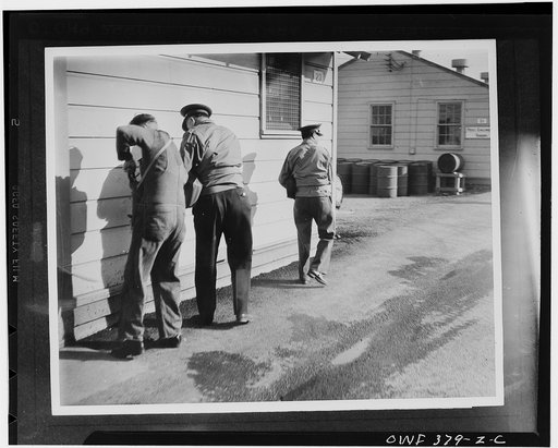 Geiger Field, Washington. Sighting the tear gas spouting jeep, these members of the Air Corps quickly don their masks. They never know when the driver is going to pull the cord and release a charge of tear gas in their direction, to ensure their being on the alert