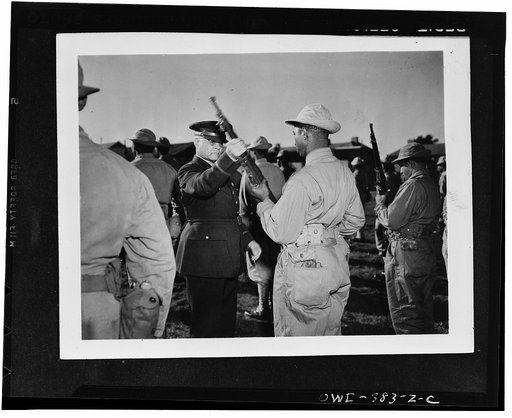 Brigadier General Benjamin O. Davis inspecting the rifle of a U.S. Negro soldier somewhere in England